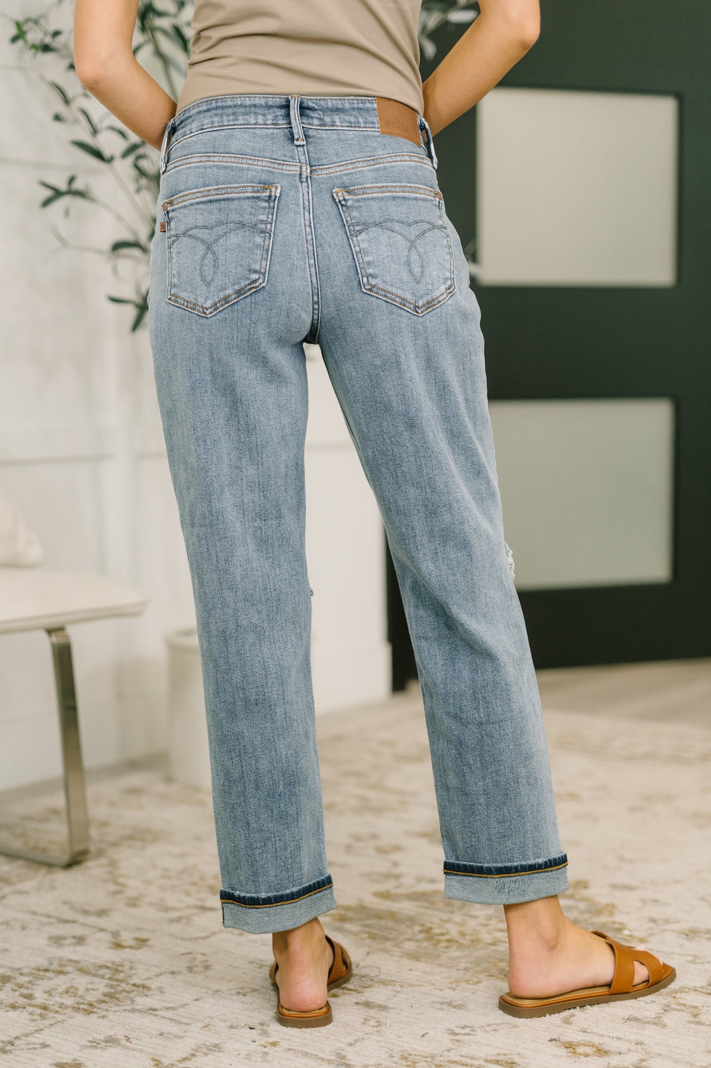 Person wearing light blue jeans with a neutral background