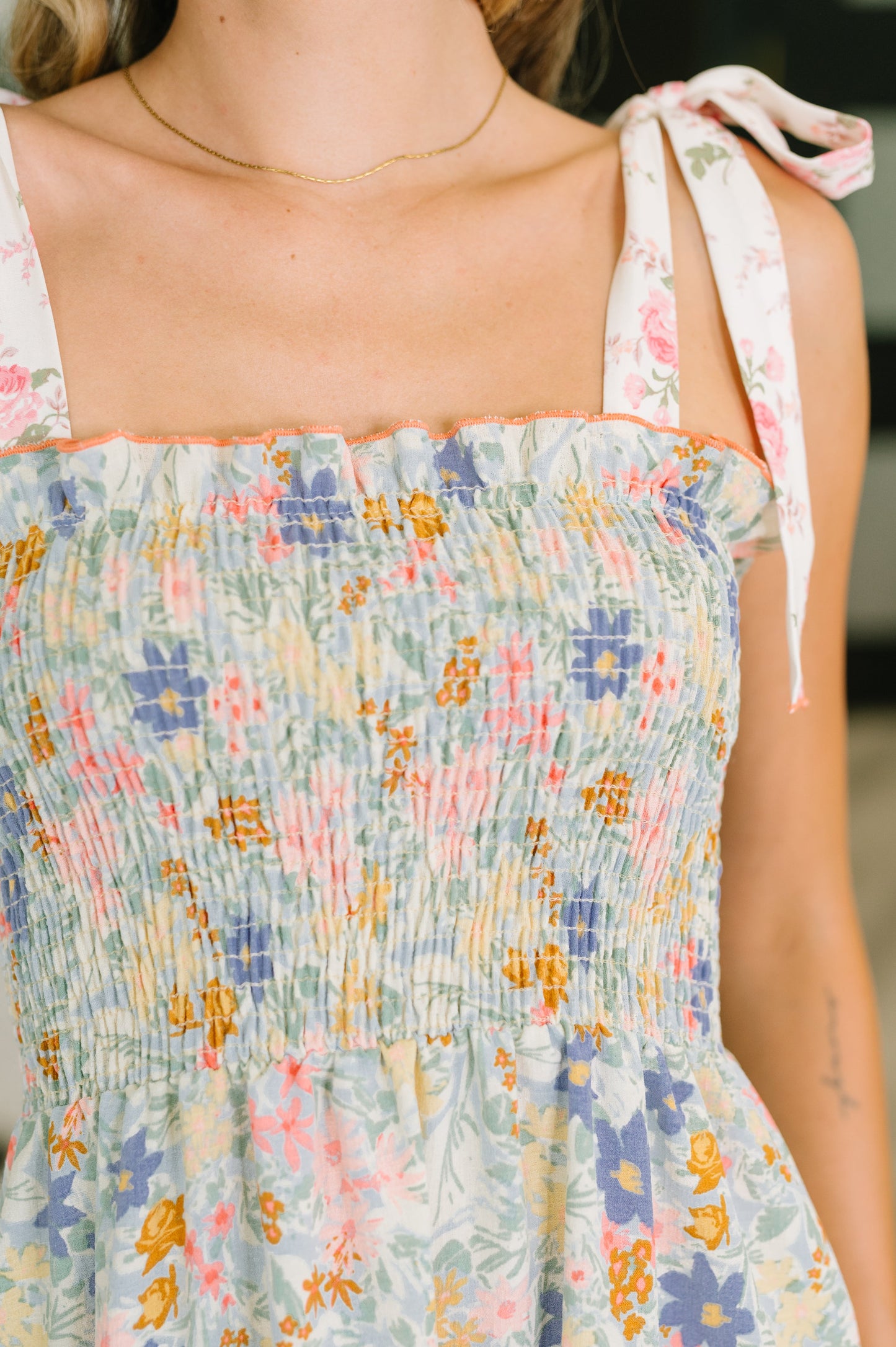 Multicolored floral dress with thin straps and a blurred background