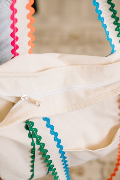 Close-up of a beige garment with colorful zigzag trim