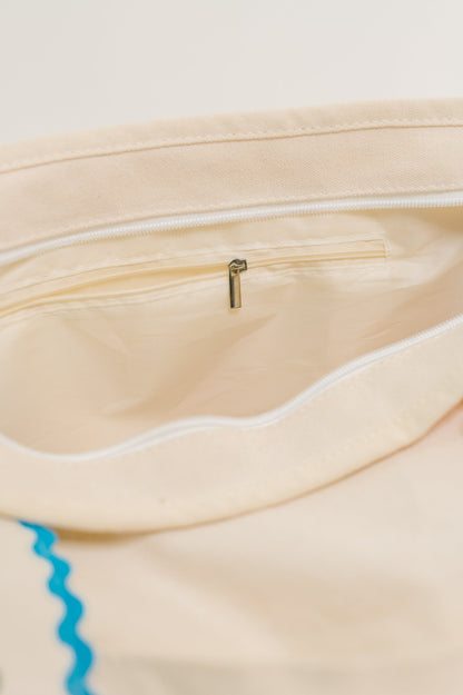 Close-up of a beige pouch with a zipper, showing the interior.