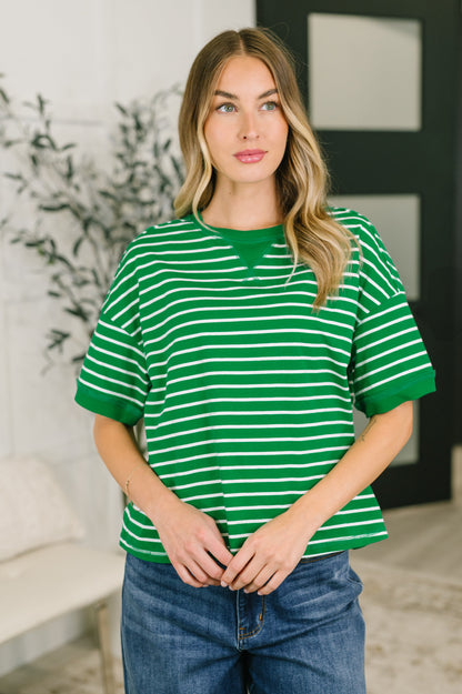 Woman wearing a green and white striped shirt in an indoor setting