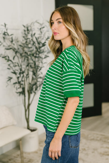 Woman wearing a green and white striped shirt in an indoor setting