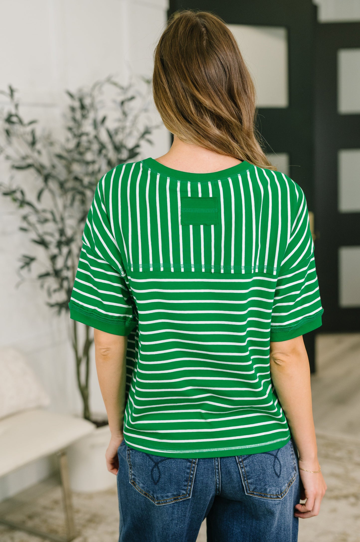 Person wearing a green and white striped shirt in an indoor setting