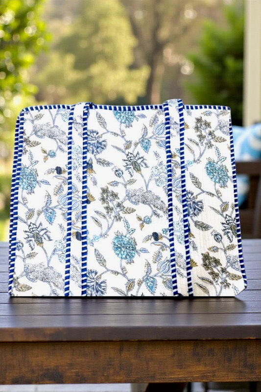 Floral-patterned fabric with blue and white design on a wooden surface