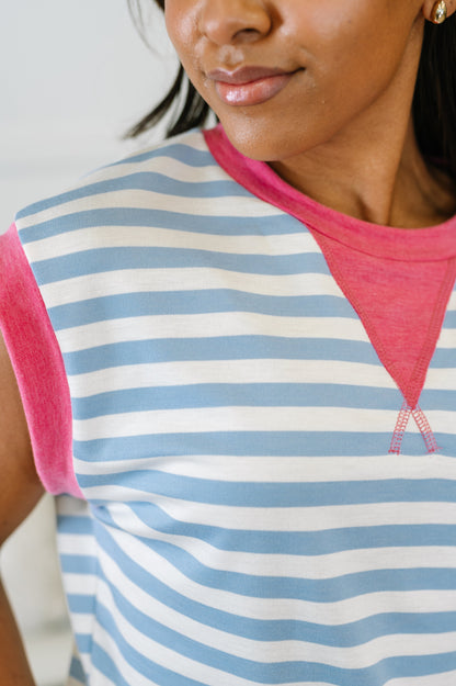 Woman wearing a striped shirt with pink sleeves and neckline.