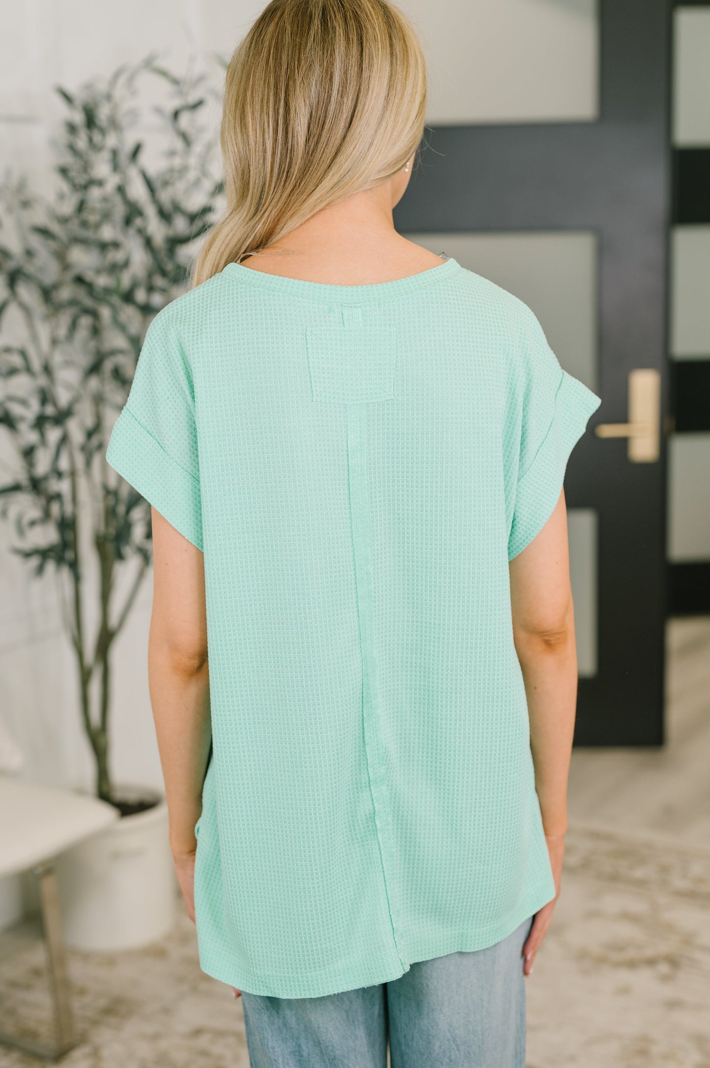 Person wearing a light green top in an indoor setting