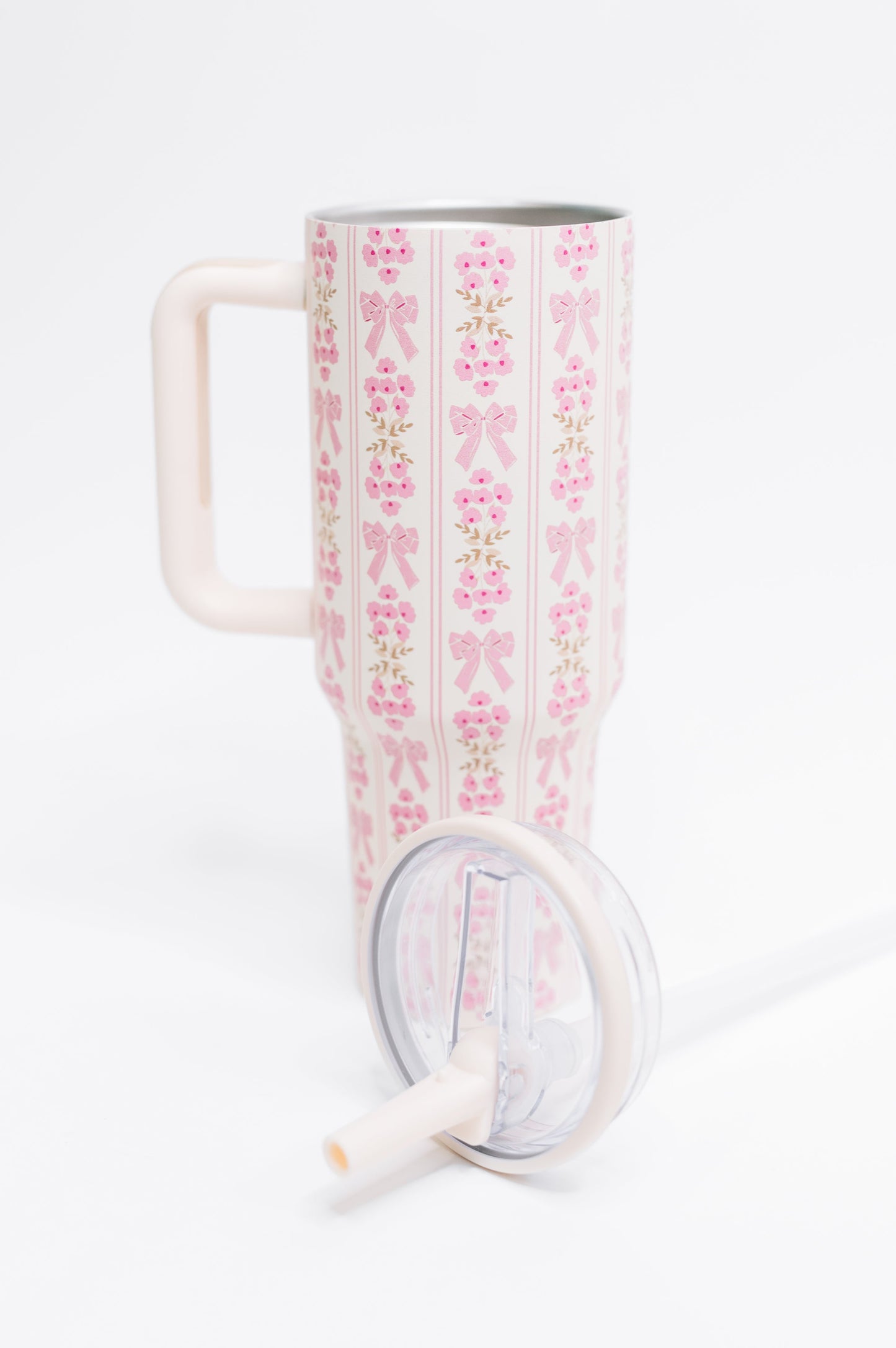 Tumbler with pink floral and bow pattern on a white background