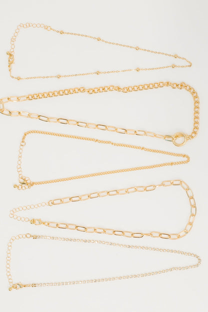Gold chain necklace on a light gray background