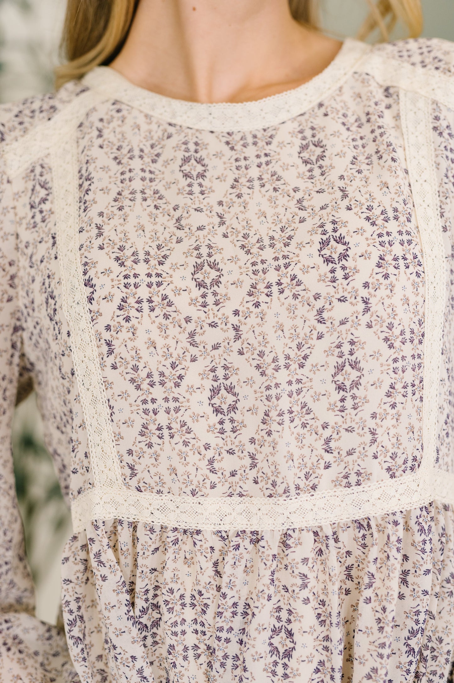 Close-up of a floral patterned dress with long sleeves.