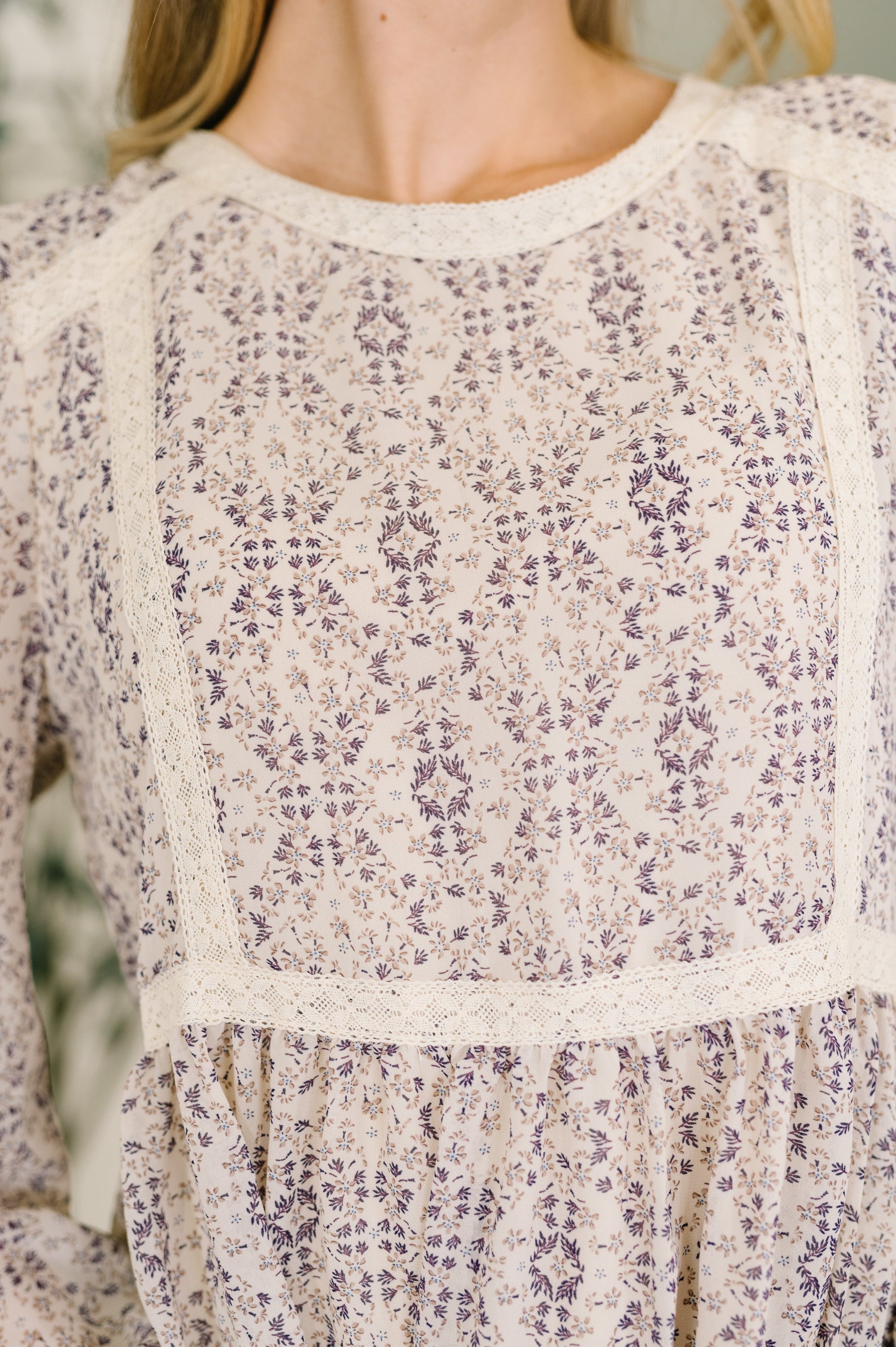Close-up of a floral patterned dress with long sleeves.