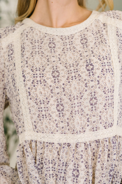 Close-up of a floral patterned dress with long sleeves.