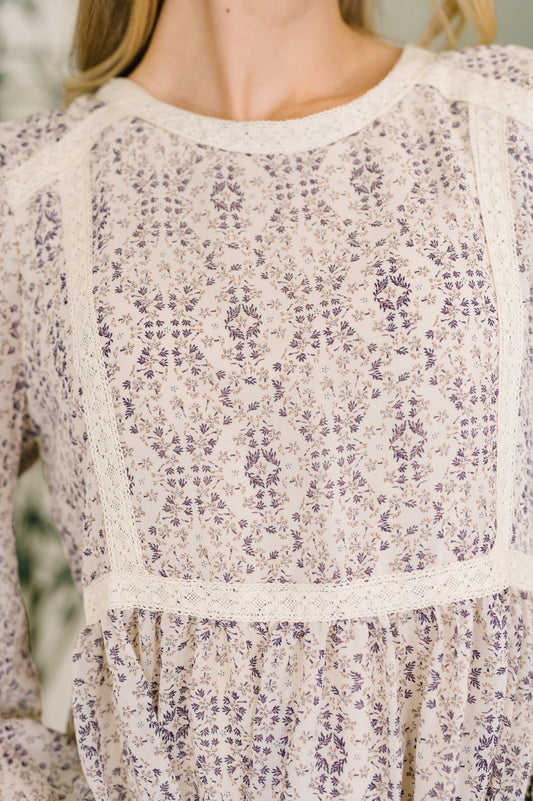 Close-up of a floral patterned dress with long sleeves.