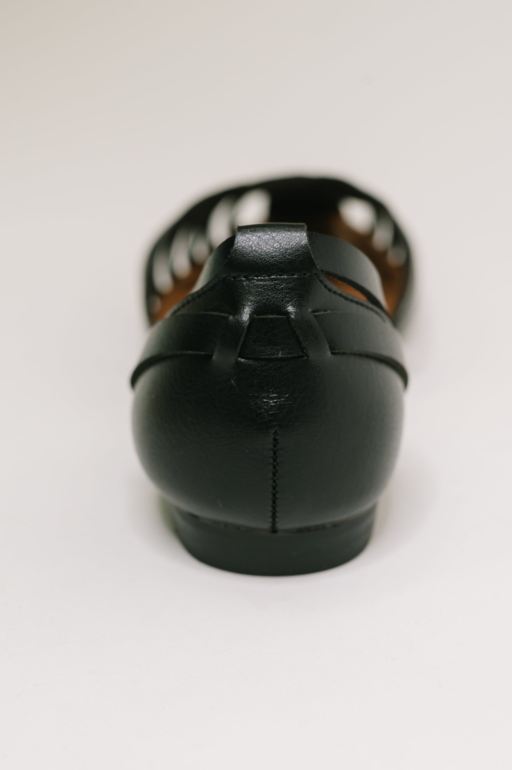 Black leather flat shoe on a white background