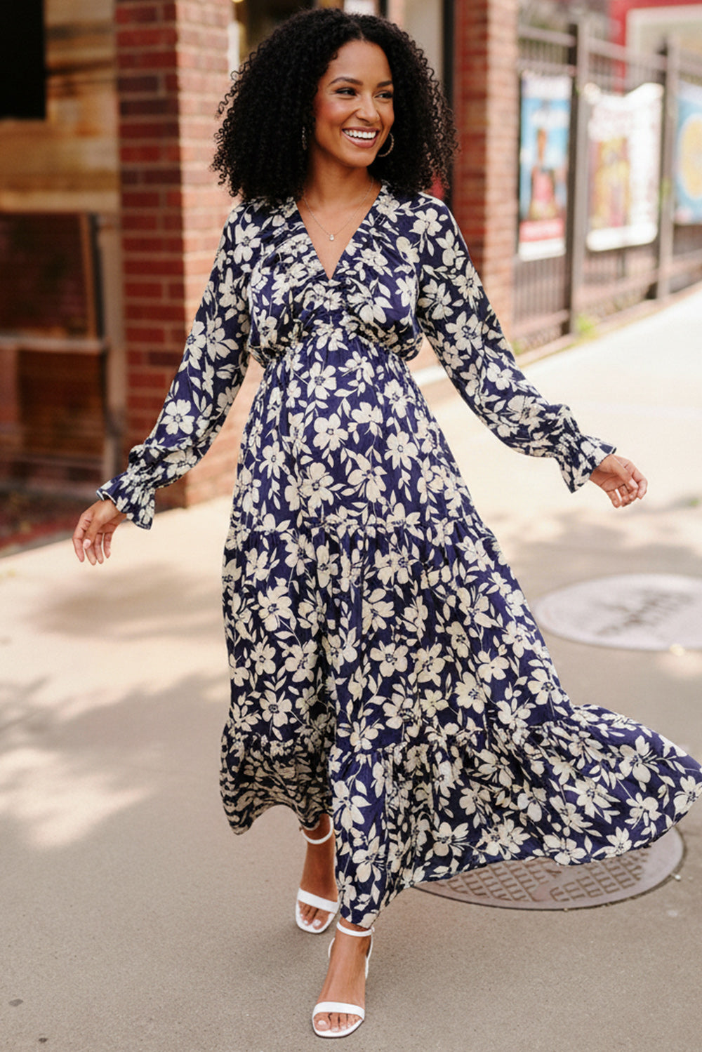 Woman wearing a blue floral dress walking outdoors.