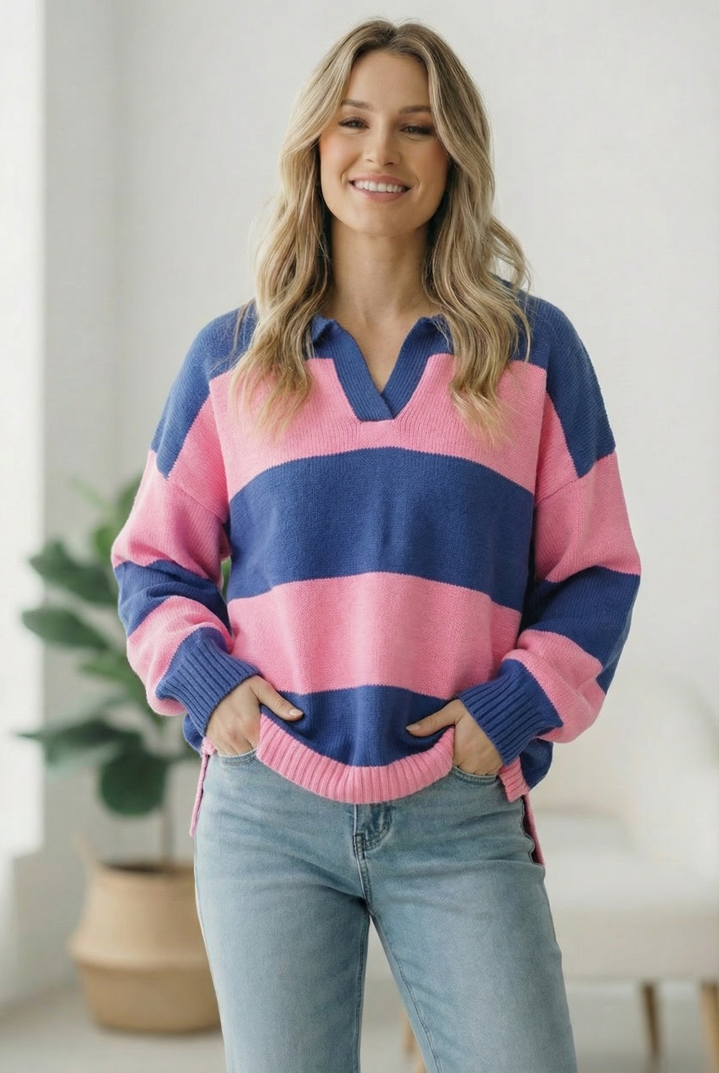 Woman wearing a pink and blue striped sweater with a blurred indoor background