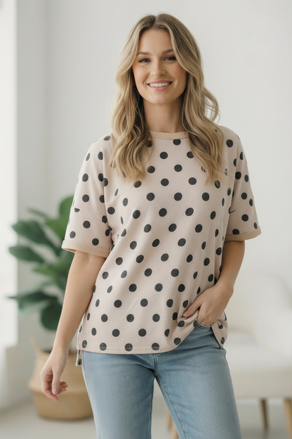 Woman wearing a polka dot shirt and jeans indoors