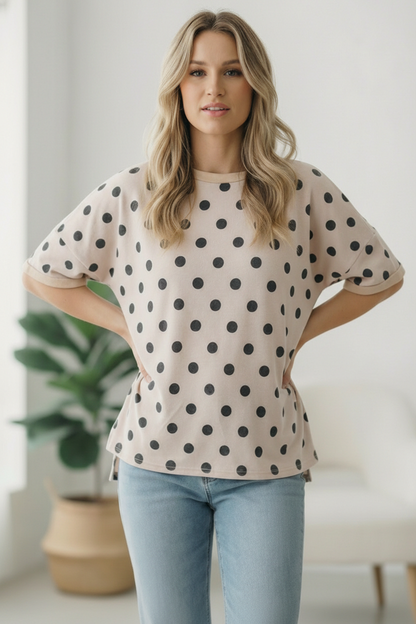 Woman wearing a polka dot blouse and jeans indoors