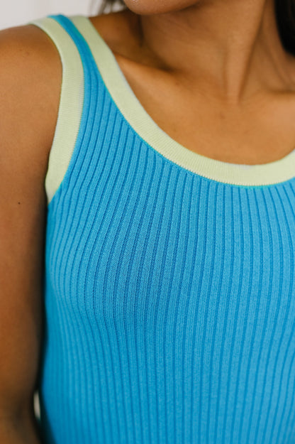 Close-up of a blue ribbed tank top with green trim.