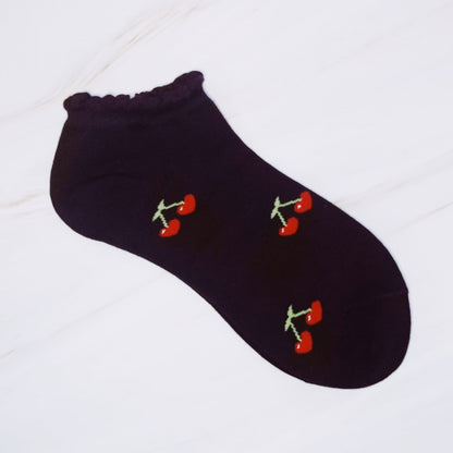 Black ankle sock with cherry designs on a white background