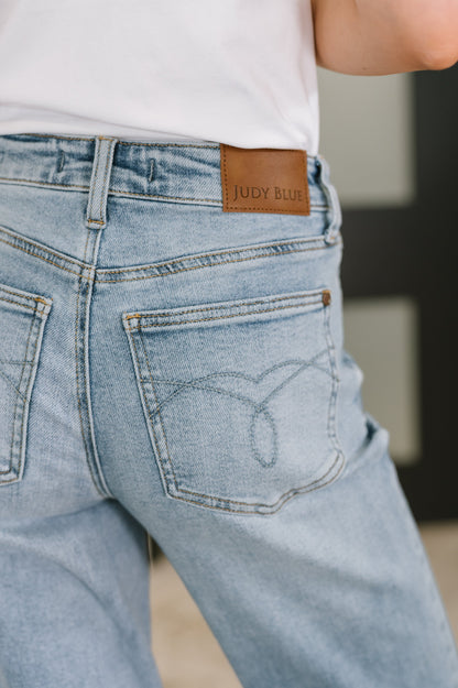 Light blue jeans with a Judy Blue label on the back pocket, worn by a person.
