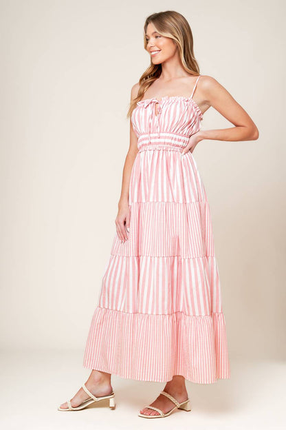 A pink and white striped dress with tiered skirt and ruffle detailing