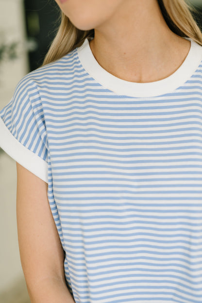 Person wearing a blue and white striped shirt with a blurred background