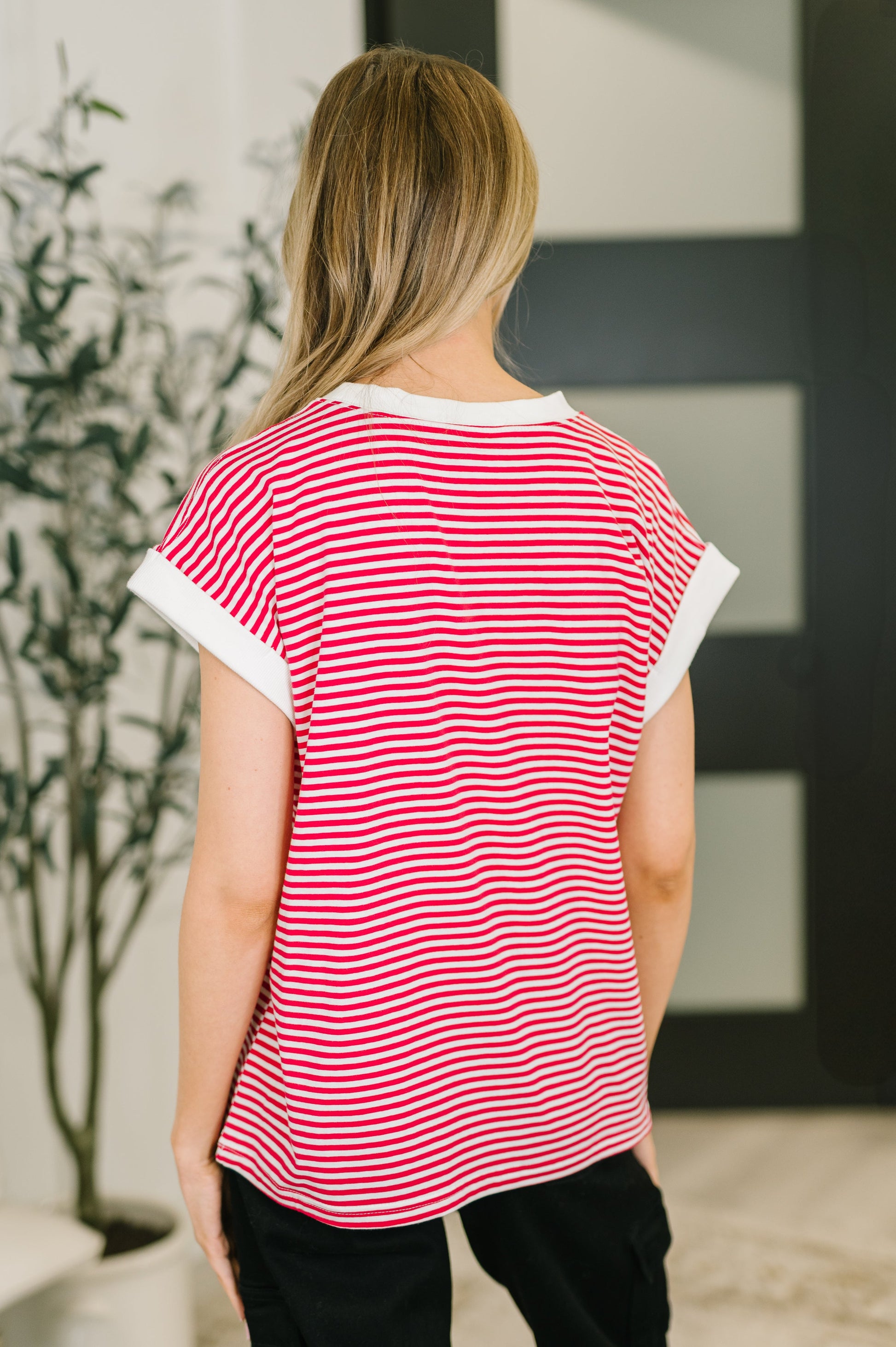 Person wearing a red and white striped shirt with a blurred background