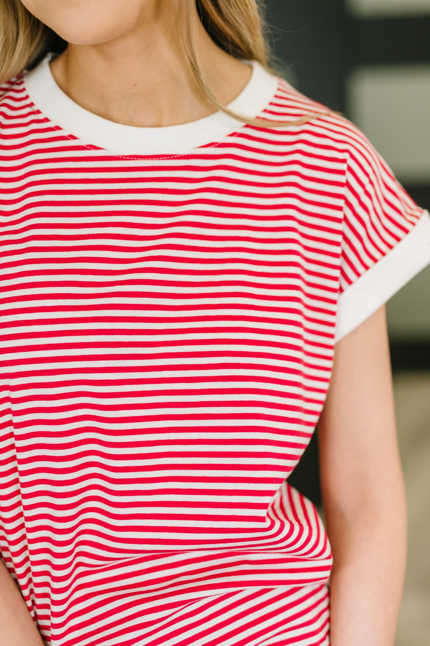 Red and white striped shirt worn by a person with a blurred background