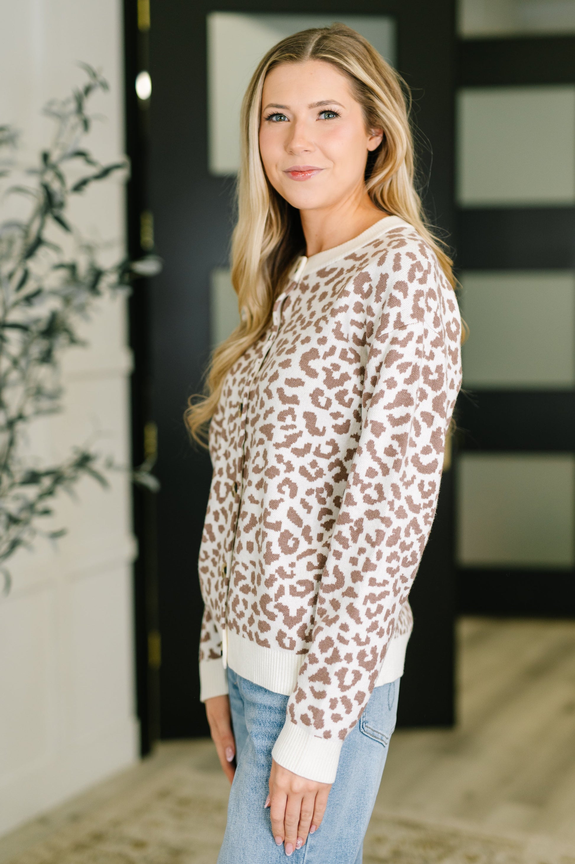 Woman wearing a leopard print sweater in an indoor setting