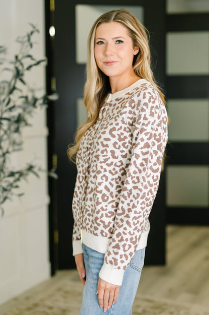 Woman wearing a leopard print sweater in an indoor setting