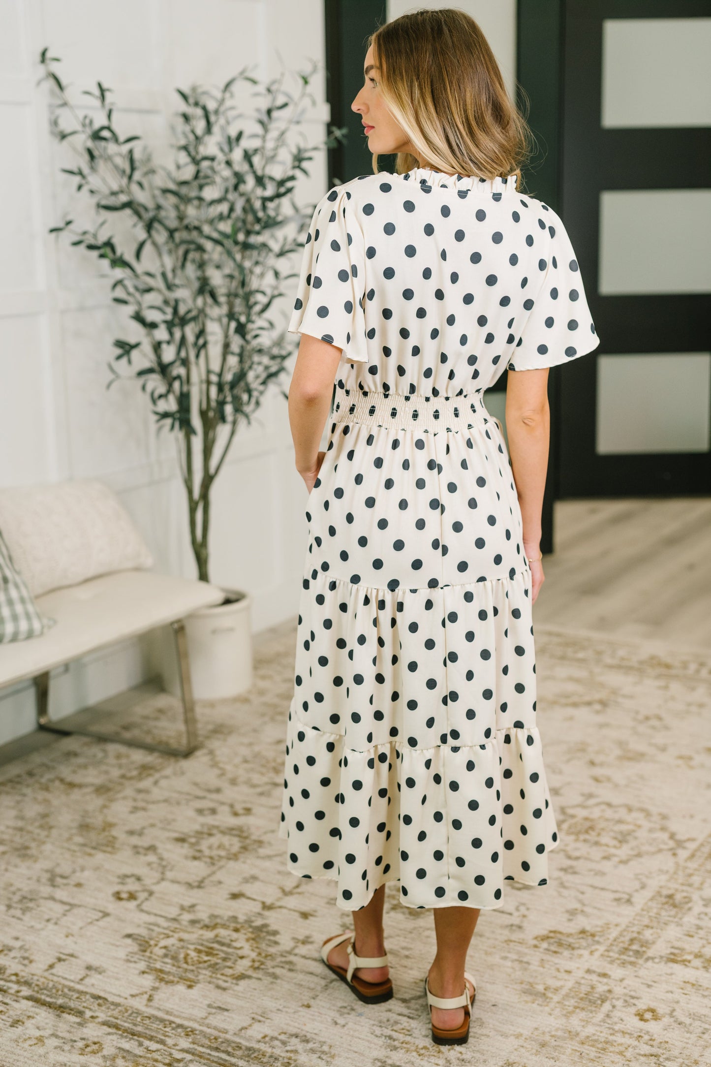 Woman wearing a polka dot dress in a living room setting