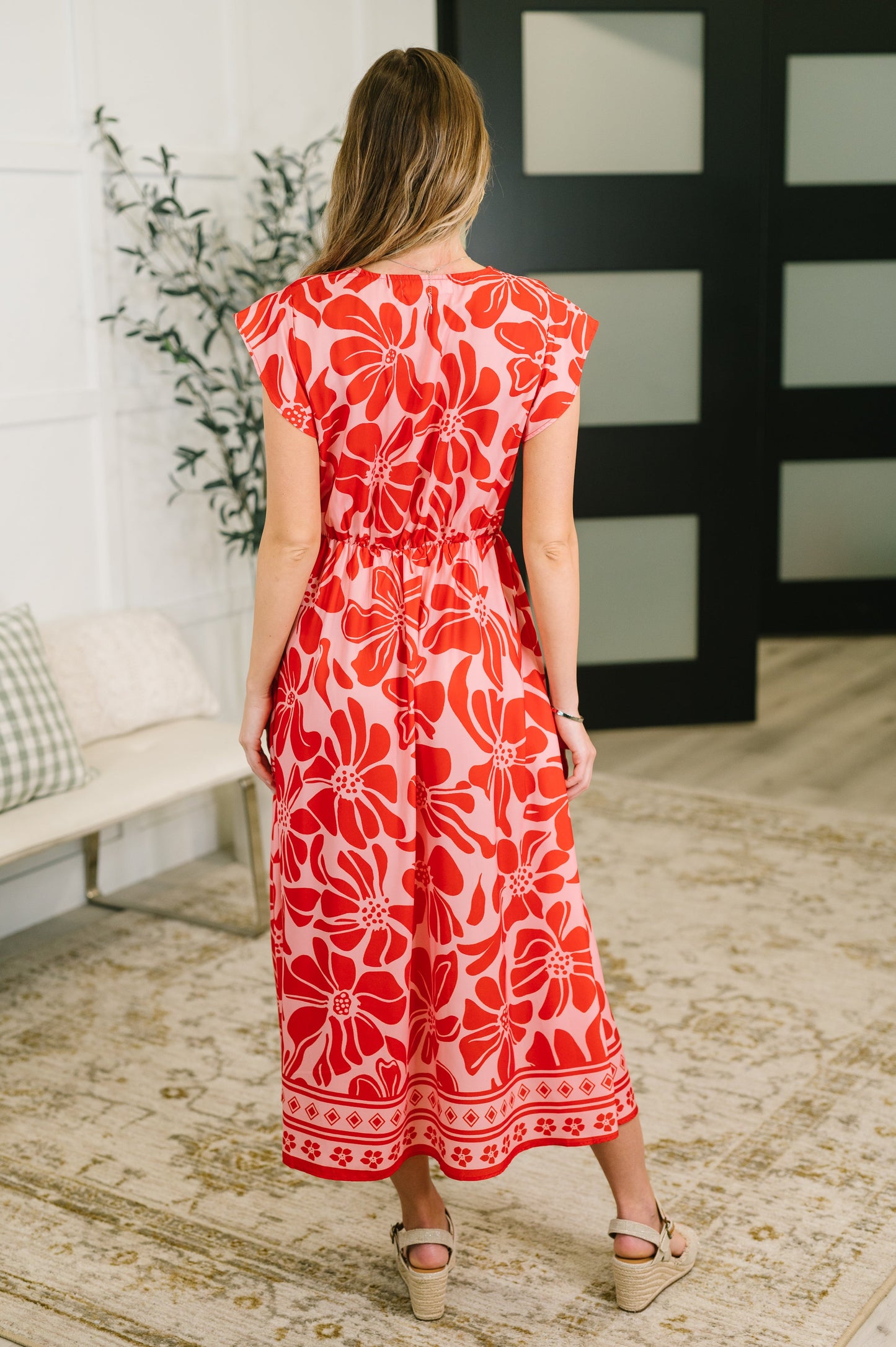 Woman wearing a red floral dress in an indoor setting