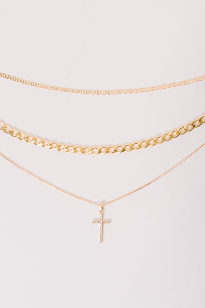 Gold necklace with a cross pendant on a white background