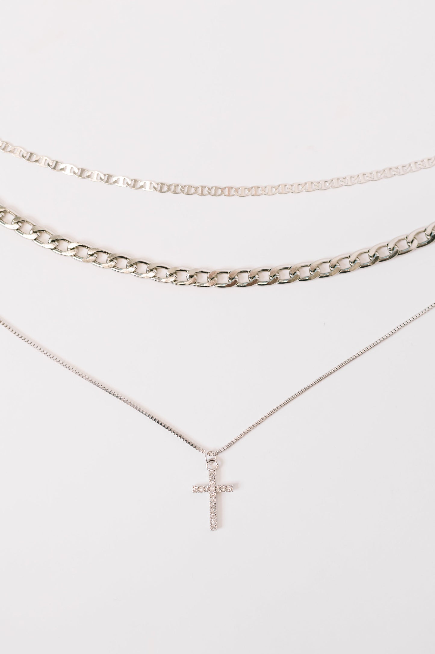 Two necklaces with a cross pendant on a white background