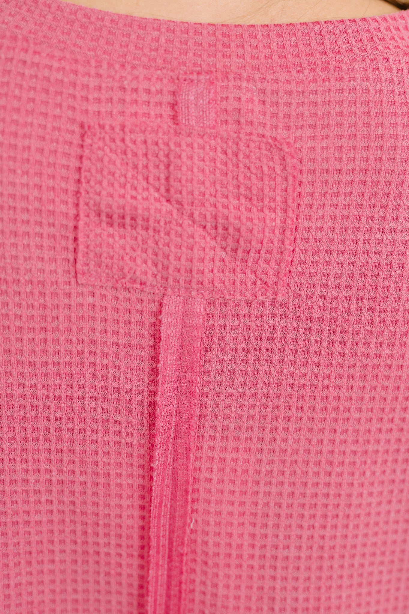 Close-up of a pink textured fabric with a zipper