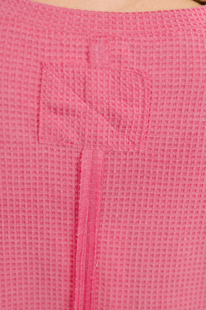Close-up of a pink textured fabric with a zipper