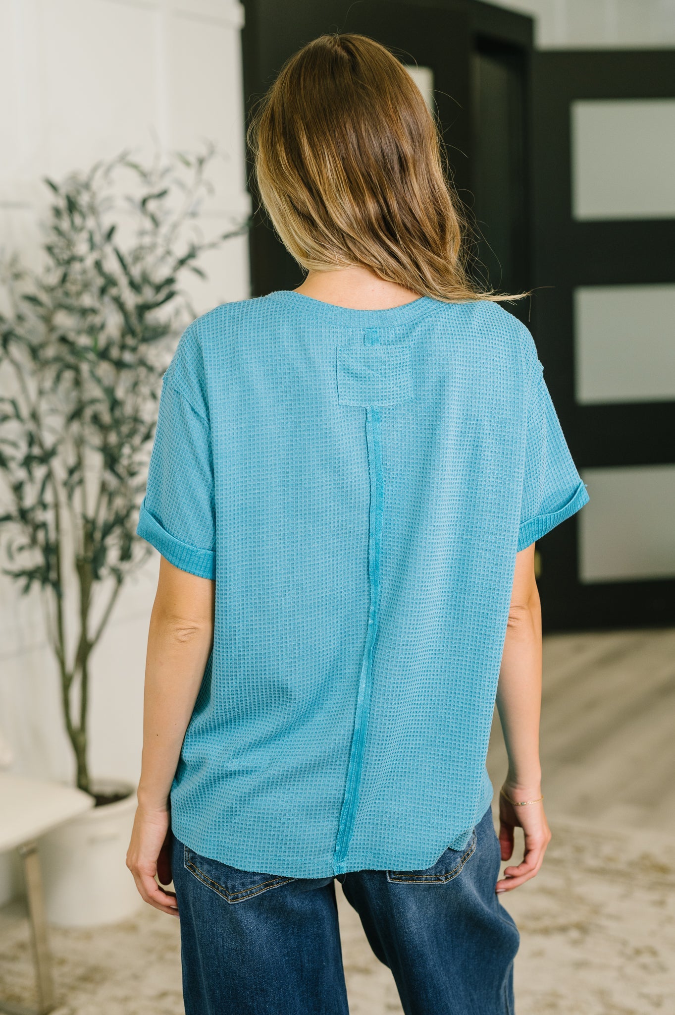 Person wearing a blue textured shirt in an indoor setting