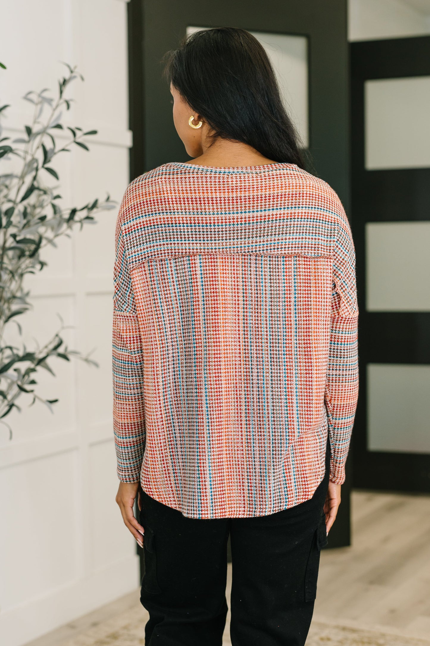 Woman wearing a plaid shirt with a neutral background