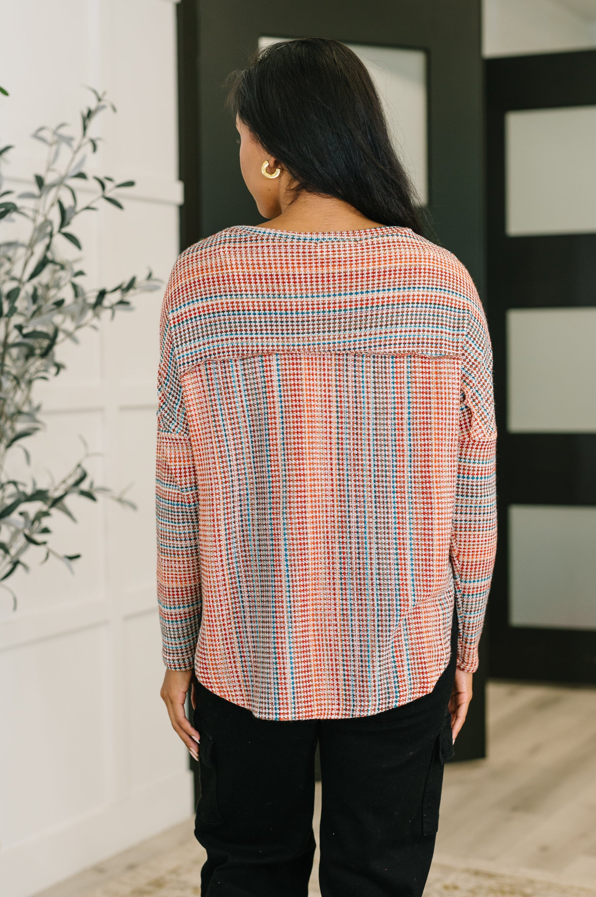 Woman wearing a plaid shirt with a neutral background
