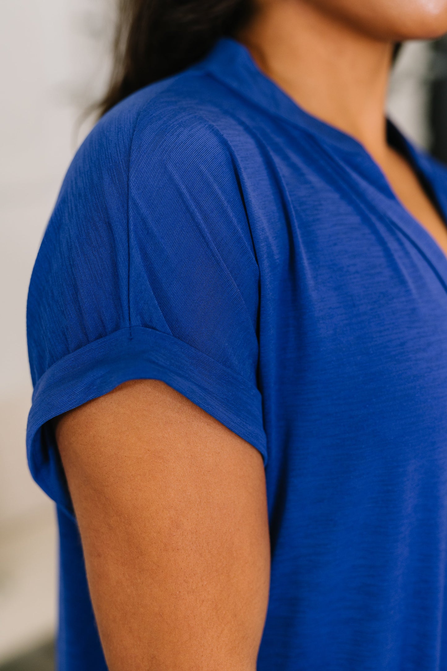 Close-up of a person wearing a blue shirt with a blurred background
