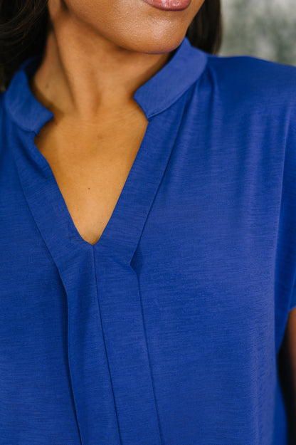 Close-up of a person wearing a blue shirt with a blurred background