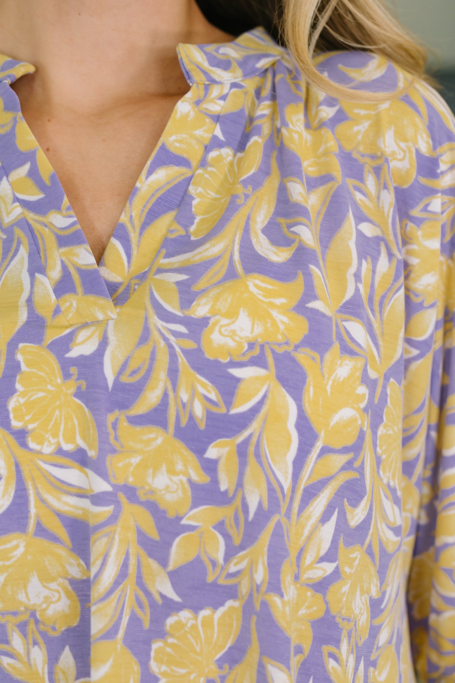 Close-up of a purple blouse with yellow floral pattern