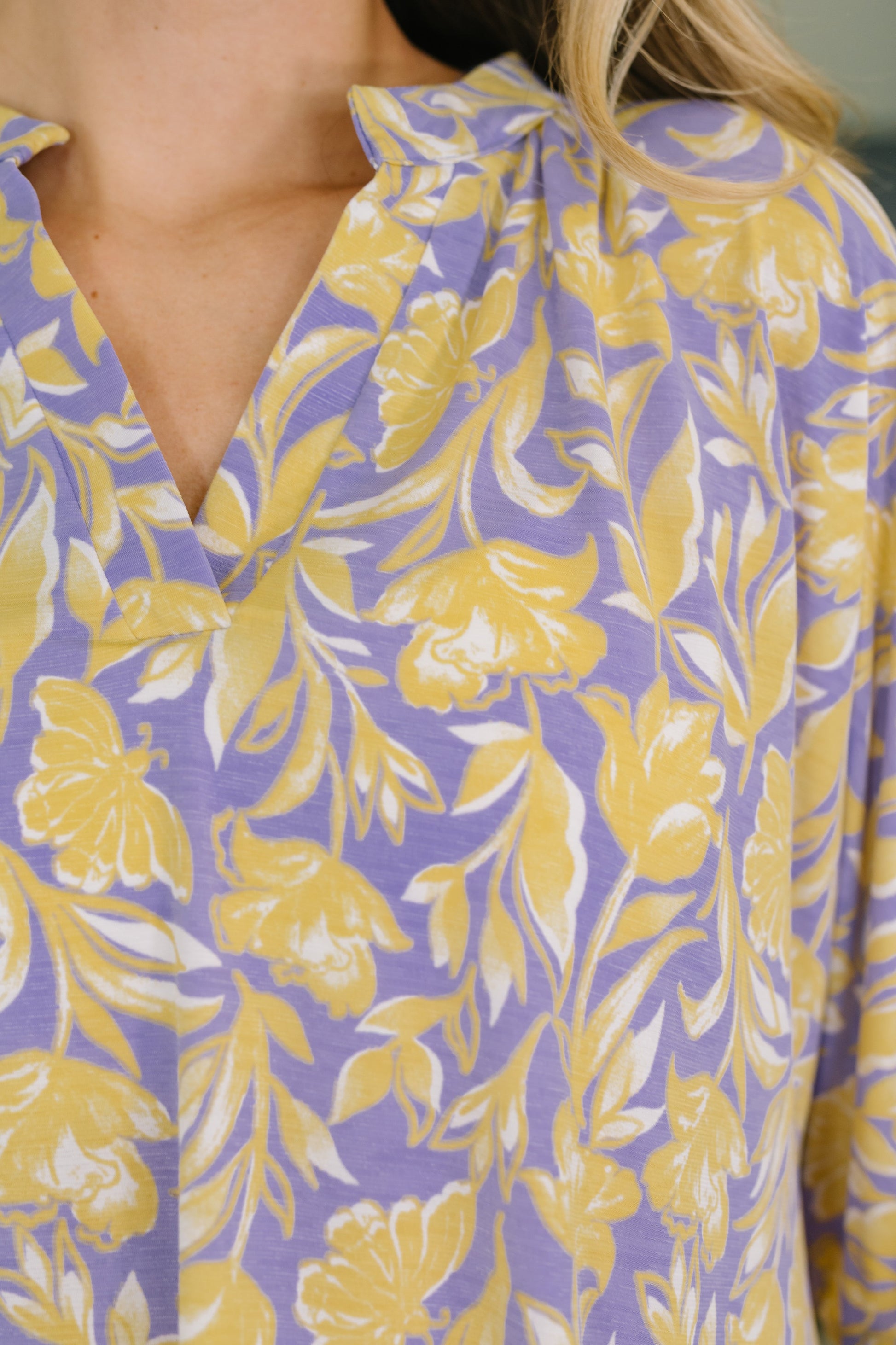 Close-up of a purple blouse with yellow floral pattern