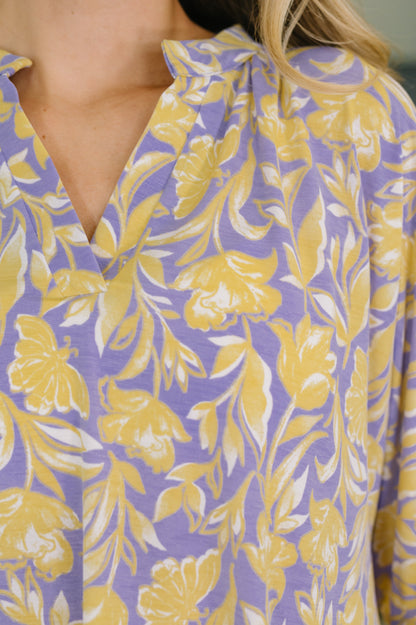 Close-up of a purple blouse with yellow floral pattern
