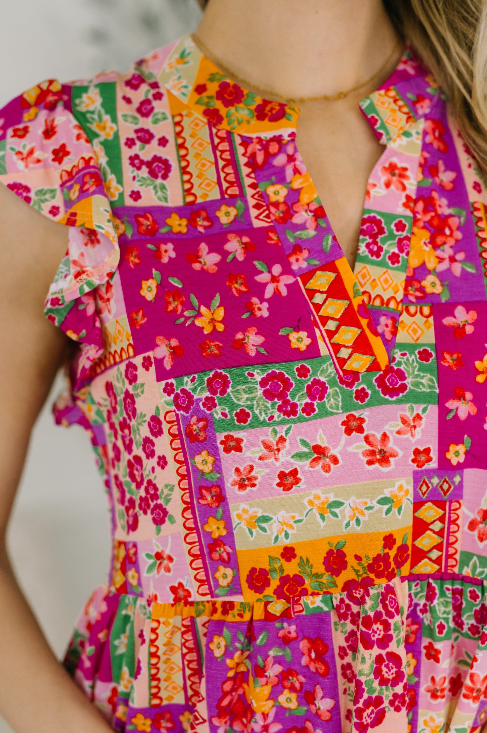 Colorful patchwork dress with floral patterns on a blurred background