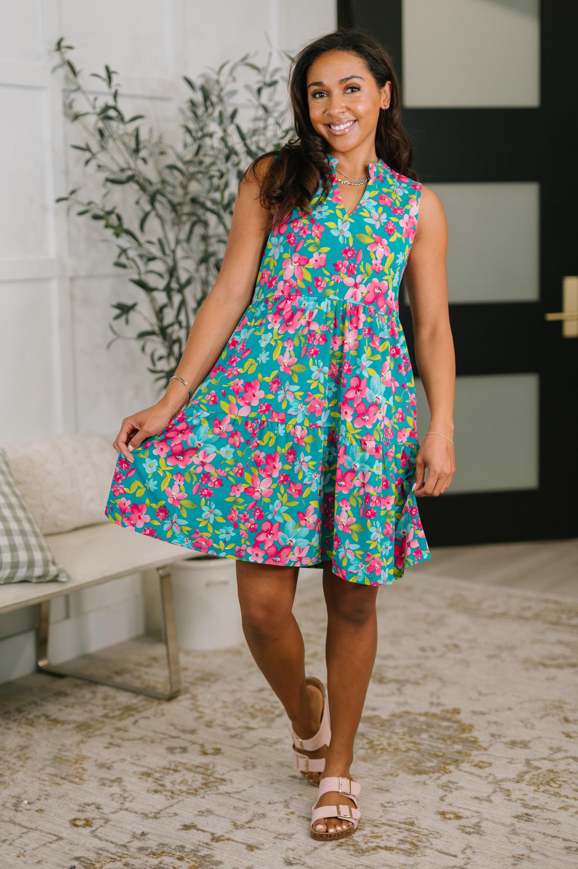 Woman wearing a colorful floral dress in an indoor setting