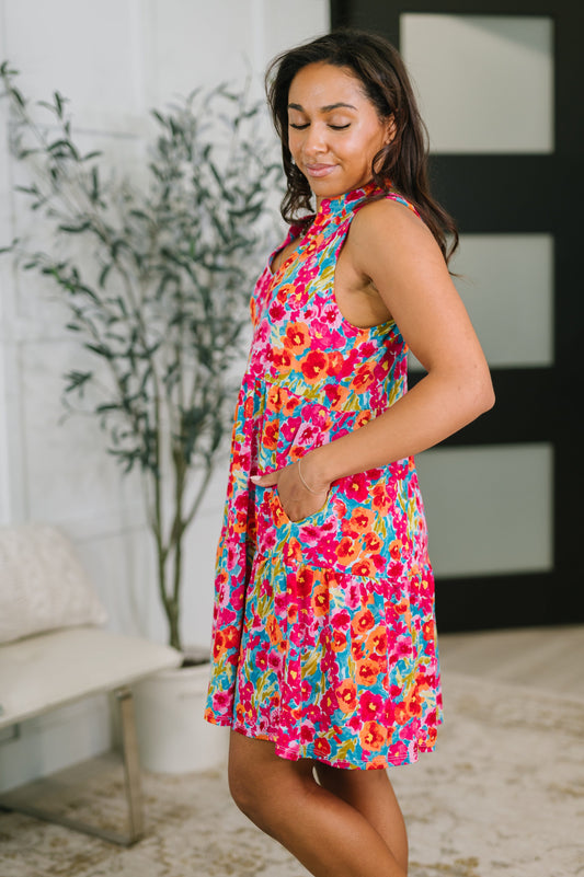 Woman wearing a colorful floral dress in an indoor setting