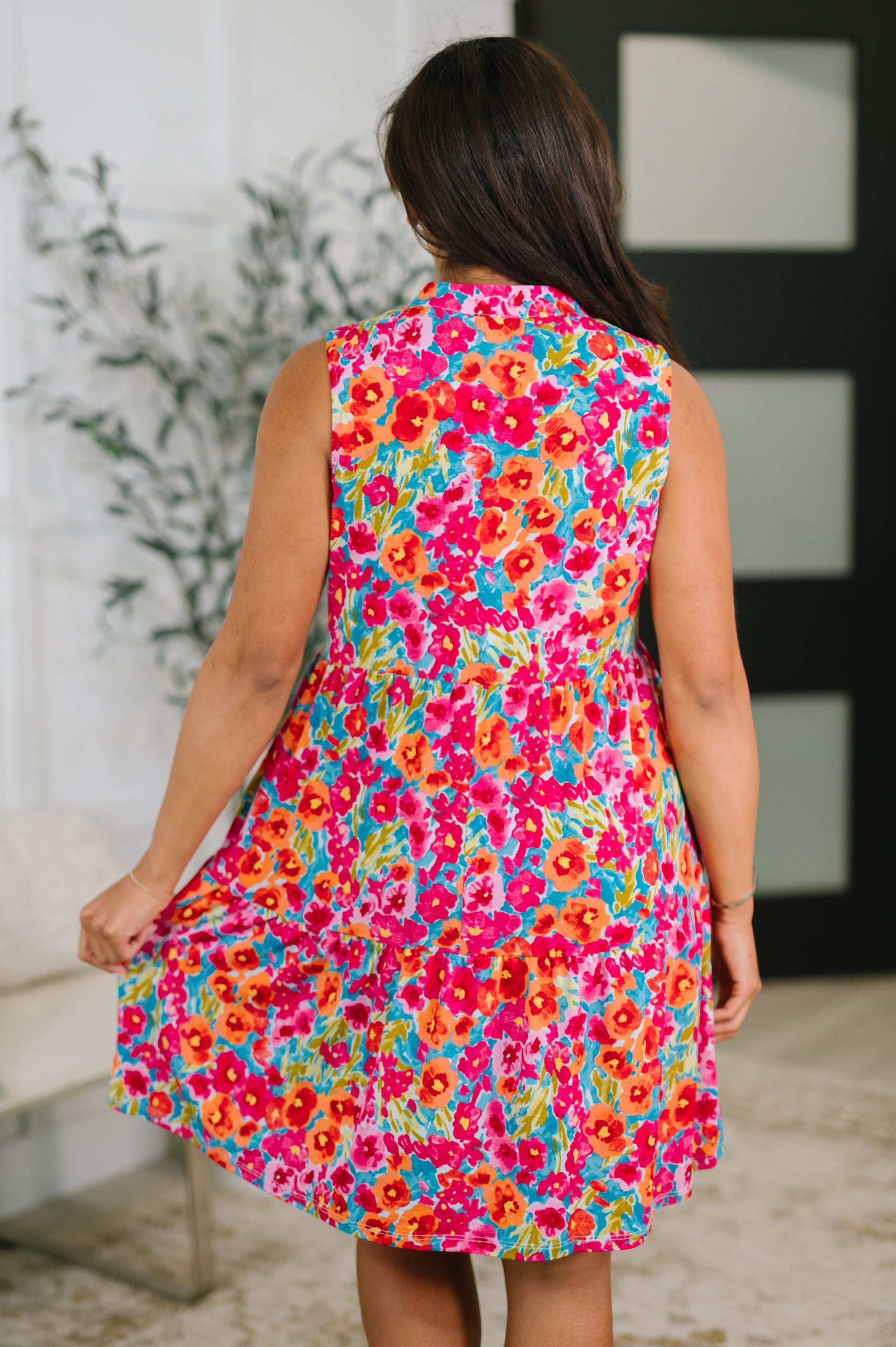 Woman wearing a colorful floral dress in an indoor setting