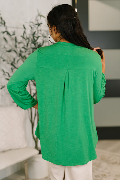 Person wearing a green long-sleeve top in an indoor setting