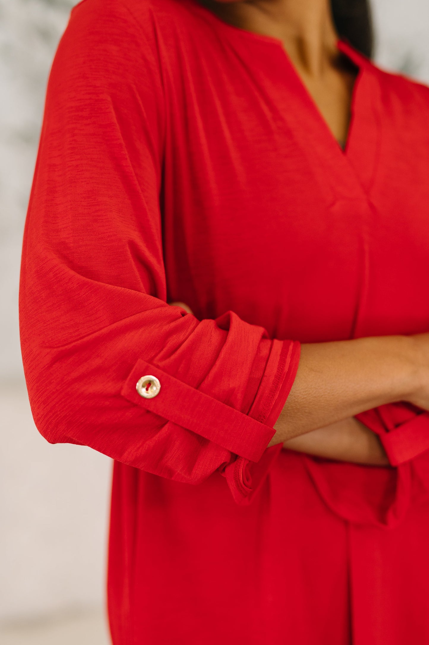 Red dress with rolled-up sleeves on a neutral background